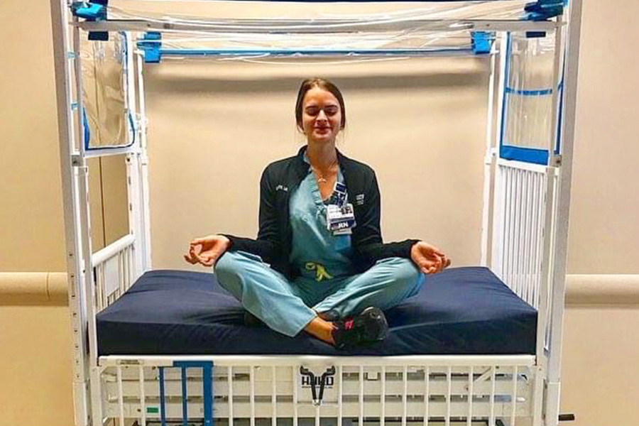 nurse wearing scrubs doing yoga in a hospital
